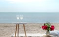 Picnic by the sea with flowers and a glass of champagne