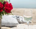 Picnic by the sea with flowers and a glass of champagne