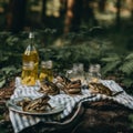 A picnic set up in the woods with a bottle of olive oil. Generative AI image.