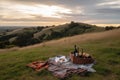 picnic setup with basket, blanket, and bottle of wine on grassy hilltop