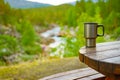 Picnic site table with thermal mug.