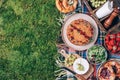 Picnic straw basket with healthy food, accessories. Summer picnic with cake, fruits, cheese, wine and snacks on plaid Royalty Free Stock Photo