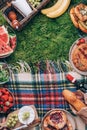 Picnic straw basket with healthy food, accessories. Summer picnic with cake, fruits, cheese, wine and snacks on plaid