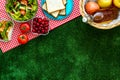Picnic in summer with products, sandwich, salad, fruits, drink on green grass texture background top view mockup