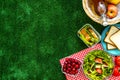 Picnic in summer with products, sandwich, salad, fruits, drink on green grass texture background top view mockup