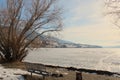 Picnic table and fire pit on shore line of frozen lake Royalty Free Stock Photo