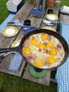 Picnic Table With A Frying Pan Cooking Bacon And Eggs