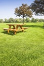 Picnic table on a green meadow public park with trees on background - Image with copy space