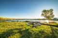 Picnic table at a park with scenic view of a lake that reflects the sky and sun Royalty Free Stock Photo