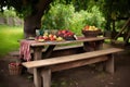 picnic table with a rustic, hand-carved bench and basket of fresh fruit