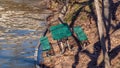 Picnic table on side of hill near edge of water, leaning uncomfortably towards water