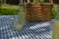 Picnic table with vintage picnic basket, blue checked table cloth Royalty Free Stock Photo