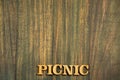 Picnic in wooden letters on rustic background