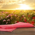 Picnic wooden table with checkered napkin and beautiful roses on background