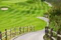 Picteresque green golf field with a fence