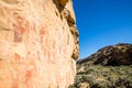 Pictographs of many figures in Central Utah on orange and red sandstone