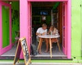 Tourists eating ice creams engrossed with their cellphones in an ice cream shop in Picton, Marlborough Sounds, New Zealand