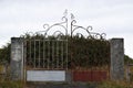 Picture of abandoned land with a old and rusted metal gate who used to be the main entrance of the property.