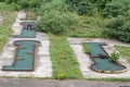 Abandoned mini golf course in a bankrupted resorts with decaying and rusting golf holes.