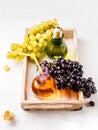 Picture from above of wooden tray with green and black grapes, two bottles of juice Royalty Free Stock Photo