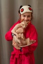 Picture of adorable young Caucasian female hugging her cute highbred pet. Sphynx cat with no fur purring in arms