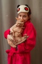 Picture of adorable young Caucasian female hugging her cute highbred pet. Sphynx cat with no fur purring in arms