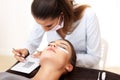 Adult woman having eyelash extension in professional beauty salon Royalty Free Stock Photo