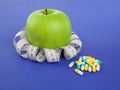 Picture of apple, pills and tape measure Royalty Free Stock Photo