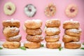 Picture of assorted donuts in a box with chocolate frosted, pink glazed and sprinkles donuts.