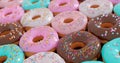 Picture of assorted donuts with chocolate frosted, pink glazed and sprinkles donuts