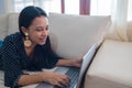 A picture of an attractive young businesswoman working on a laptop on the couch