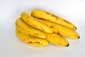 A branch of overripe bananas with brown spots.