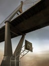 Picture of Basketball wooden backboard with the hoop orange metal ring and the white net contrast with the suspension bridge, Royalty Free Stock Photo