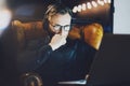 Picture bearded man wearing glasses working modern loft office. Young banker sitting vintage chair,listening music Royalty Free Stock Photo