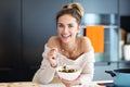 Beautiful Smiling Woman Eating Fresh Organic Vegetarian Salad In Modern Kitchen Royalty Free Stock Photo