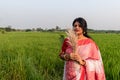 A picture of a Bengali girl wearing a red and white sari in a vast paddy field in autumn Royalty Free Stock Photo