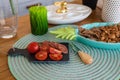 Tomatoes, sloced sausages, cookies in the plate and a green grass candle in the kitchen