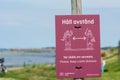 Picture from Borstahusen beach and a sign with a reminder to remember to keep a safe distance. Going to the beach is a