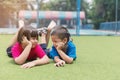 Picture of brother and sister having fun in the park, two cheerful children laying down on green grass, little girl and boy Royalty Free Stock Photo