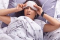 Picture of brunette lady waking up in morning with bed mood, lying in bed on gray pillow with astonished expression, with a bit Royalty Free Stock Photo