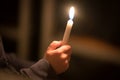 burning church candles in the hands of children on a dark background Royalty Free Stock Photo