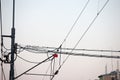 Catenary power overhead line of a railroad track, supplying electricity for trains, with a pylon pillar in the background Royalty Free Stock Photo