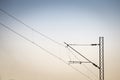 Catenary power overhead line of a railroad track, supplying electricity for trains, with a pylon pillar in the background Royalty Free Stock Photo