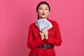 Picture of charismatic lovely rich young bussinesswoman holding fan of money, keeping lips together, earning money, having high