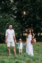 Beautiful mum, dad and their cute little child have fun together and smiles outside Royalty Free Stock Photo