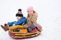 Picture of cheerful girl and boy riding on tubing Royalty Free Stock Photo
