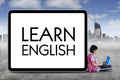 Clever schoolgirl with word of Learn English