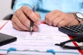 Picture of clipboard, form, glasses, calculator, pen and phone. Man is holding pen in hand Royalty Free Stock Photo