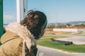 Close-up of girl from behind watching a motorcycle race from the stands