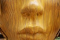 Closeup of a wooden face of a sculpture at a park